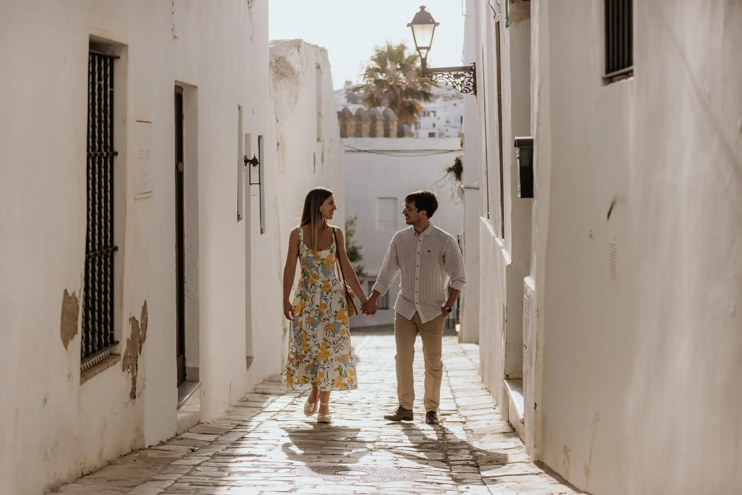 La pareja pasea entre casas encaladas con rejas de hierro en Vejer de la Frontera