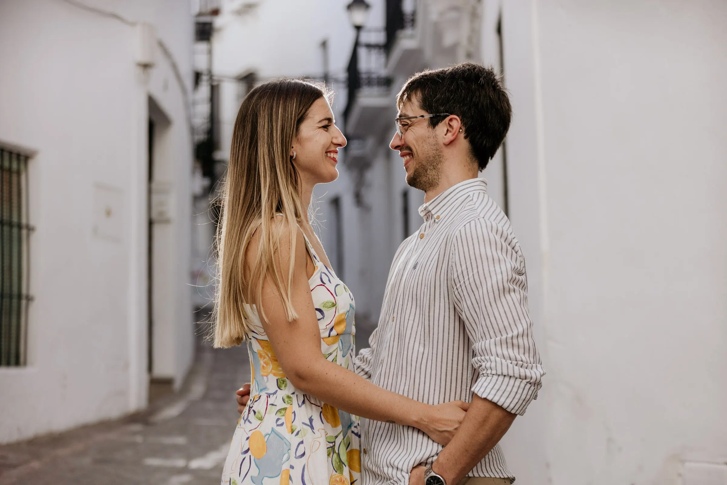 La pareja ríe frente a frente en un callejón encalado de Vejer de la Frontera