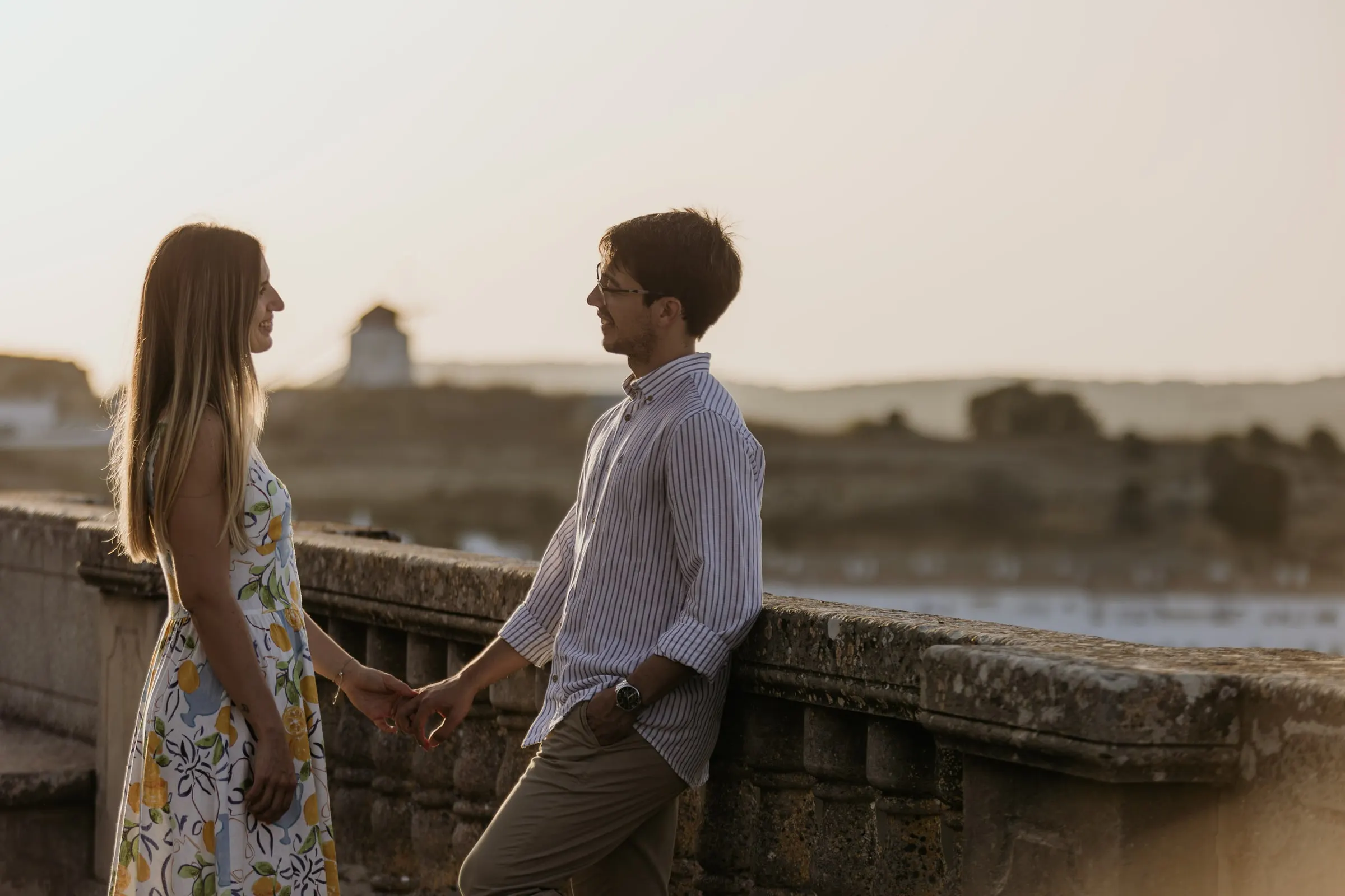 La pareja de la mano en el mirador con un molino en el horizonte, Vejer de la Frontera