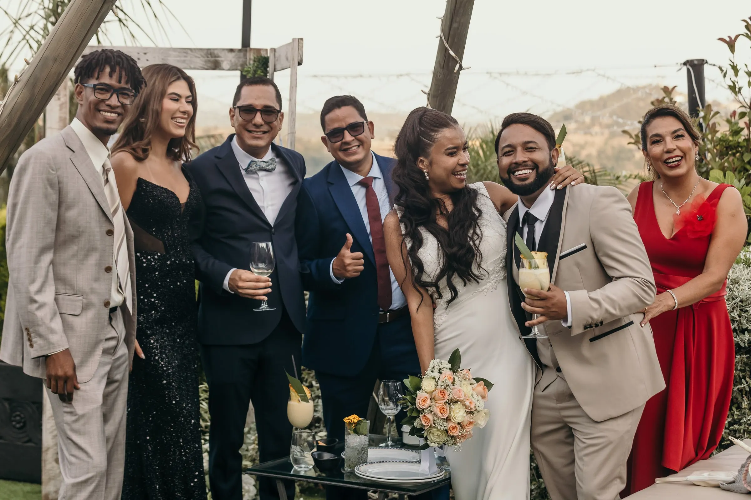Bride and friends laughing with cocktails in hand at the drinks reception