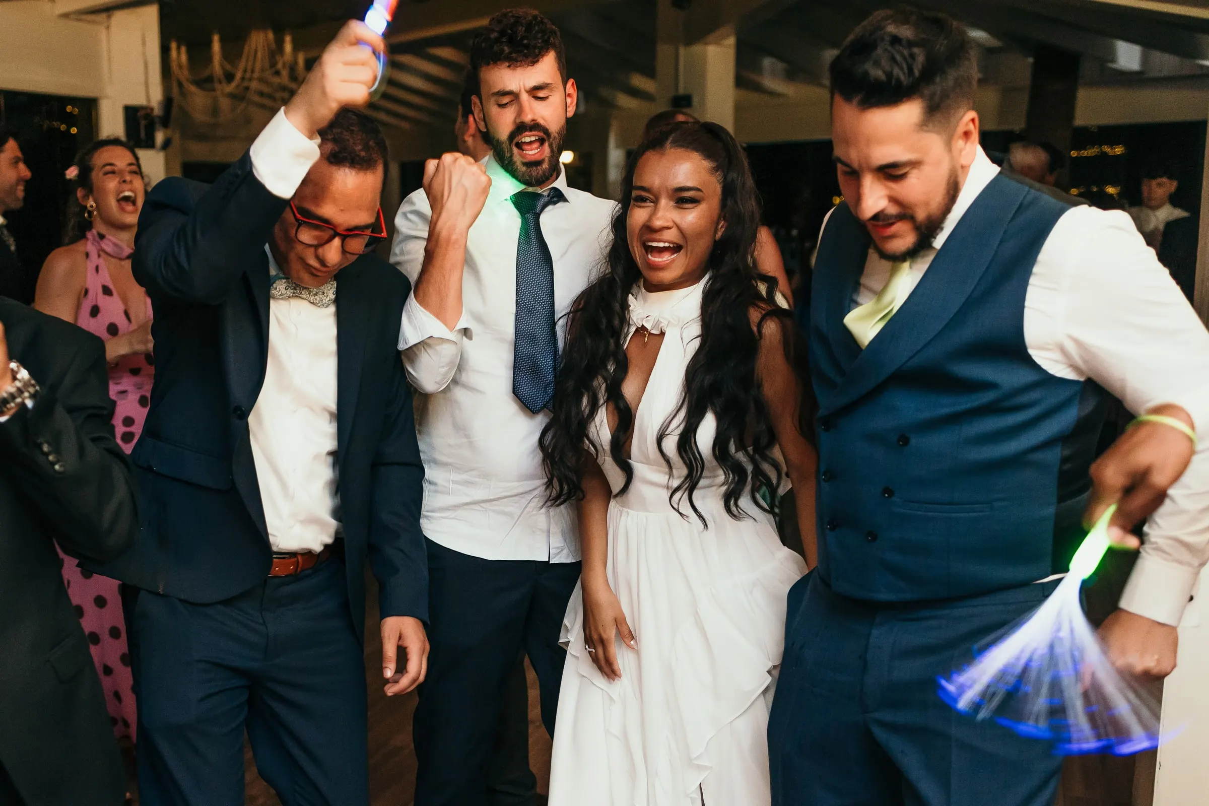 La novia con su segundo vestido de fiesta con el novio y los amigos en la pista